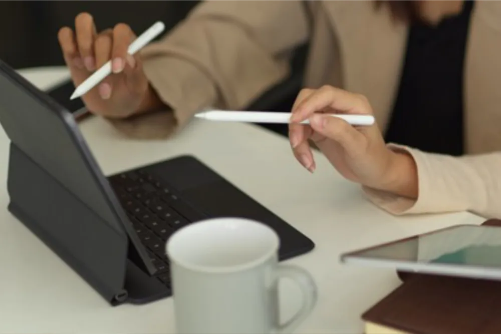 desktop with two women looking at laptop computer